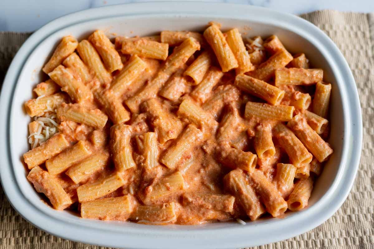 Two layers of ziti noodles with mozzarella cheese in the middle