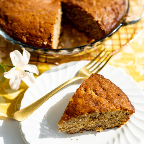 A slice of banana bread next to a pie plate.