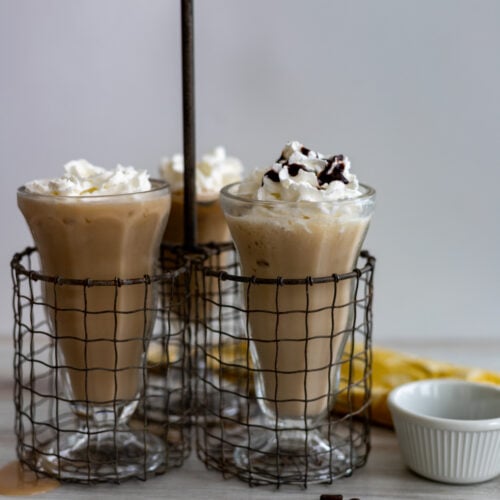 Coffee milkshakes topped with whipped cream and chocolate syrup.